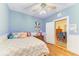 Light blue bedroom with a ceiling fan and wood floors with a view of the dining room at 2509 8Th W Ave, Bradenton, FL 34205