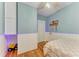 Light blue bedroom featuring a ceiling fan, wainscotting, and wooden floors at 2509 8Th W Ave, Bradenton, FL 34205
