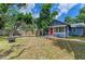 Charming blue home with a red door, inviting front porch, and well-manicured lawn at 2509 8Th W Ave, Bradenton, FL 34205