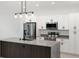 Contemporary kitchen featuring white cabinets, a stylish island, stainless steel appliances, and modern lighting at 2638 Hagerick Ln, North Port, FL 34288