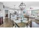Open dining area with modern lighting open to the kitchen with bar stool seating and living area at 3162 27Th E Ct, Palmetto, FL 34221