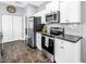 Well-lit kitchen featuring stainless steel appliances, white cabinetry, and dark wood flooring at 3162 27Th E Ct, Palmetto, FL 34221