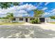 Well-maintained home with a large circular driveway, black shutters, and tropical landscaping in the front yard at 3808 Cape Vista Dr, Bradenton, FL 34209