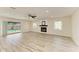 Spacious living room with sliding glass doors to screened lanai, a modern fireplace, and neutral walls at 3808 Cape Vista Dr, Bradenton, FL 34209