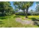 Large backyard with mature trees, lush green lawn, and glimpses of the house, emphasizing outdoor space at 3988 Berlin Dr, Sarasota, FL 34233