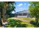 Backyard view showcasing the enclosed lanai and lush green lawn, highlighting outdoor living and landscaping at 3988 Berlin Dr, Sarasota, FL 34233
