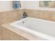 A relaxing bathtub with neutral tile and decor, perfect for unwinding at 3988 Berlin Dr, Sarasota, FL 34233