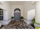 Elegant entryway with tiled flooring, potted plants, and a view of the front door at 3988 Berlin Dr, Sarasota, FL 34233
