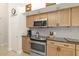 This kitchen features stainless steel appliances, light wood cabinets, and tiled backsplash at 3988 Berlin Dr, Sarasota, FL 34233