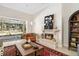 Bright living room featuring a stone fireplace, stylish decor, and a large window overlooking the pool at 3988 Berlin Dr, Sarasota, FL 34233