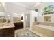 Large bathroom with tub, chandelier, double vanity, walk-in shower, and tile floors at 3988 Berlin Dr, Sarasota, FL 34233
