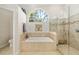 Bathroom with bathtub, shower, arched window and tile floors at 3988 Berlin Dr, Sarasota, FL 34233