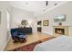 Bedroom boasts hardwood floors, fireplace, TV, and a comfortable chair with ottoman at 3988 Berlin Dr, Sarasota, FL 34233
