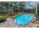Inviting screened-in pool with rock features and stone surround, creating a backyard oasis at 3988 Berlin Dr, Sarasota, FL 34233