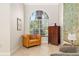 Cozy sitting area with an upholstered chair and cabinet, bathed in natural light from a large window at 3988 Berlin Dr, Sarasota, FL 34233