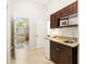 Wet bar with cabinets and mini refrigerator leading to an ensuite bathroom at 3988 Berlin Dr, Sarasota, FL 34233