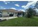 Large backyard with a patio, lush green grass, and mature trees, offering a private outdoor retreat at 4027 Allure Ln, North Port, FL 34287