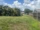 Wide backyard view with grass, a chainlink fence, and a wooden fence with a home in the background at 4027 Allure Ln, North Port, FL 34287