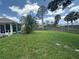 Large backyard with lush green grass and a wood fence, perfect for outdoor activities at 4027 Allure Ln, North Port, FL 34287
