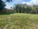Expansive grassy backyard, perfect for outdoor activities, surrounded by mature trees and partial fencing at 4027 Allure Ln, North Port, FL 34287