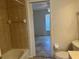 Bathroom featuring a toilet, tub with tile surround, and view into bedroom at 4027 Allure Ln, North Port, FL 34287