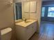 Bathroom vanity with sink, cabinet storage, mirror, and view into Primary bedroom at 4027 Allure Ln, North Port, FL 34287