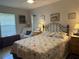 Comfortable bedroom with a decorative wrought iron bed frame, soft lighting, and a cozy reading chair by the window at 4027 Allure Ln, North Port, FL 34287