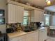 Charming kitchen featuring white cabinets, a mosaic backsplash, and an undermounted double sink at 4027 Allure Ln, North Port, FL 34287