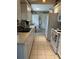 Efficient galley-style kitchen with white cabinets and appliances, and tile flooring at 4027 Allure Ln, North Port, FL 34287