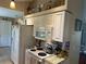 Galley kitchen with white appliances and cabinets, featuring a mosaic backsplash at 4027 Allure Ln, North Port, FL 34287
