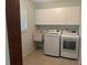 Well-equipped laundry room with sink, storage cabinets, and modern washer/dryer at 4027 Allure Ln, North Port, FL 34287