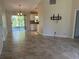 Bright living room featuring neutral tile floors, sliding glass doors and seamless access to kitchen at 4027 Allure Ln, North Port, FL 34287
