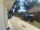 Side yard featuring a concrete patio with bins, a chain link fence, and greenery at 4027 Allure Ln, North Port, FL 34287