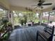 Cozy sunroom with screened windows, a ceiling fan, and views of the lush backyard at 4027 Allure Ln, North Port, FL 34287