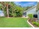 Lush backyard with mature trees and landscaping, offering a private outdoor space with a view of the pool lanai at 4322 Concert St, Port Charlotte, FL 33948