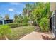 Backyard featuring a well-maintained lawn and tropical plants offering privacy and natural beauty at 4322 Concert St, Port Charlotte, FL 33948