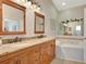Bathroom with double sinks, granite countertops, jacuzzi tub, and decorative lighting at 4322 Concert St, Port Charlotte, FL 33948