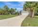 Beautiful single-story home with a long driveway, tropical palm trees, and an attached two-car garage at 4322 Concert St, Port Charlotte, FL 33948