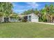 Inviting single-story home with a well-manicured lawn, mature trees, and an attached two-car garage at 4322 Concert St, Port Charlotte, FL 33948