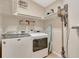 Functional laundry room with washer, dryer, shelves, and cleaning supplies, complete with laundry organizing accessories at 4322 Concert St, Port Charlotte, FL 33948