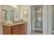 Bright bathroom featuring a granite vanity, a large mirror, and a glass-enclosed shower, perfect for relaxation at 4325 46Th W Ave # 203, Bradenton, FL 34210