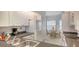 Well-lit kitchen features white cabinets and modern appliances with a view to the dining area at 4325 46Th W Ave # 203, Bradenton, FL 34210