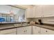 Bright kitchen with stainless steel sink, white cabinetry, and a pass-through window to the living area at 4325 46Th W Ave # 203, Bradenton, FL 34210