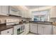 Well-lit kitchen featuring white cabinets, stainless steel appliances, and a convenient dishwasher for easy cleanup at 4325 46Th W Ave # 203, Bradenton, FL 34210
