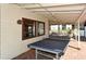 Outdoor ping pong table sits on a brick patio near community building windows at 4325 46Th W Ave # 203, Bradenton, FL 34210