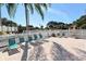 Community pool deck featuring lounge chairs, a covered picnic area, and palm trees at 4325 46Th W Ave # 203, Bradenton, FL 34210