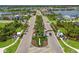 Aerial view of Canoe Creek neighborhood featuring lush green landscaping and a grand entrance at 4407 Big Woods Way, Parrish, FL 34219