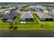 Aerial view shows a well-maintained yard, patio, and lake, perfectly positioned between neighboring properties at 4407 Big Woods Way, Parrish, FL 34219