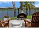 Cozy backyard features a modern fireplace, comfortable seating, and scenic water views at 4407 Big Woods Way, Parrish, FL 34219