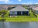 An aerial view reveals the backyard oasis, complete with a patio, lush lawn, and lake backdrop at 4407 Big Woods Way, Parrish, FL 34219